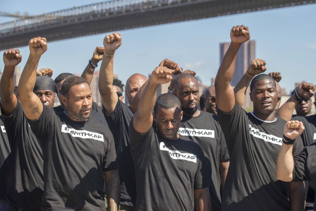 Members of law enforcement raise their fists during a rally to show support for Colin Kaepernick, Saturday, Aug. 19, 2017<br>